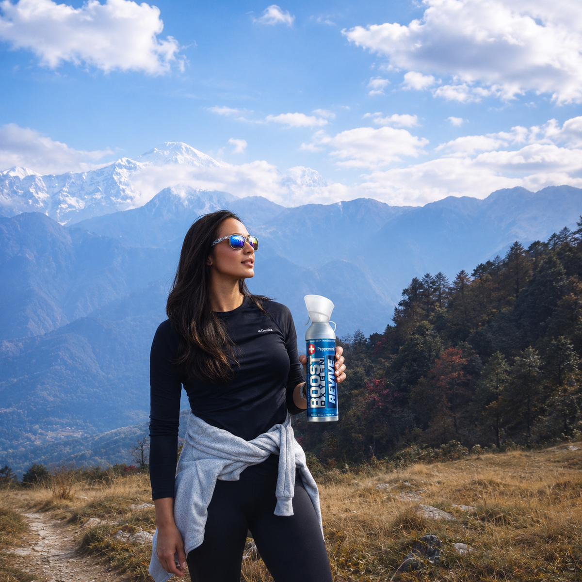 Woman hiking holding a canister of Boost Oxygen Revive with mountains in the background