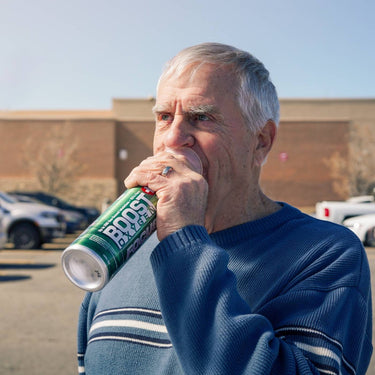 Older man using Boost Oxygen Focus in a parking lot.