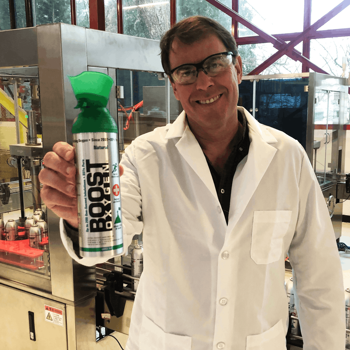 Boost Oxygen Founder with a lab coat and safety glasses on holding a can of Boost Oxygen