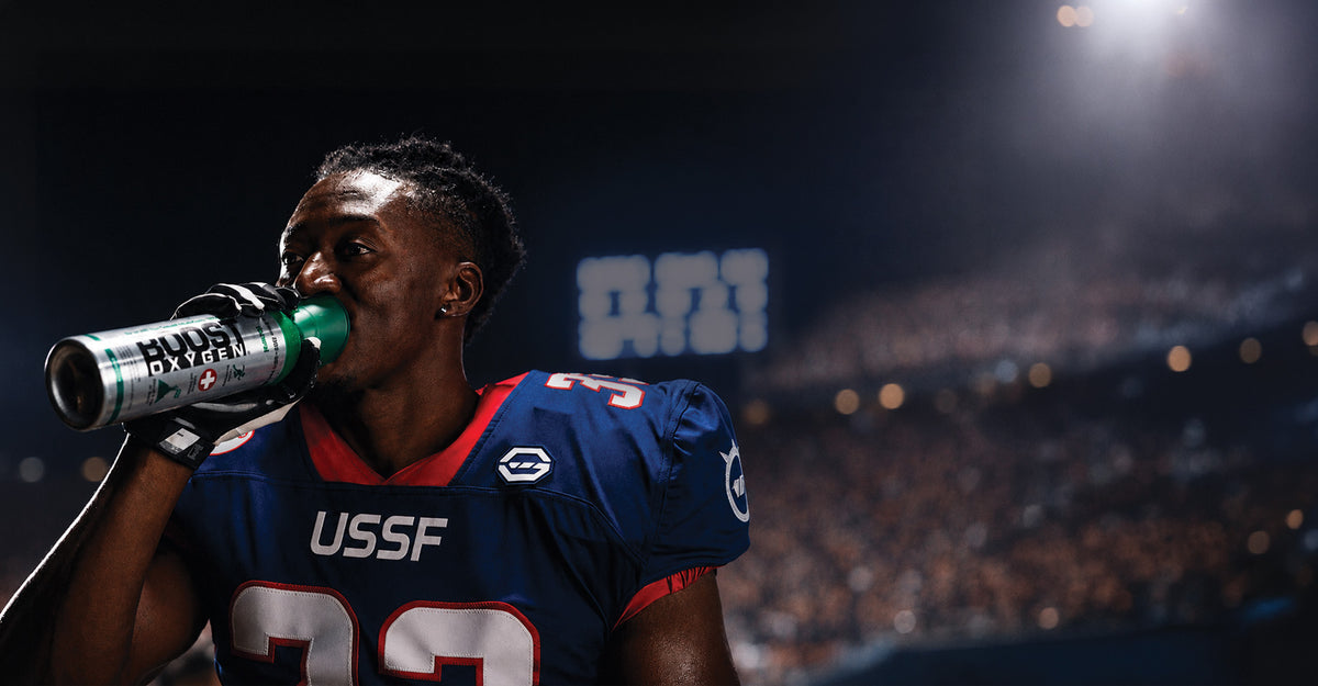 Football player is in a stadium under the lights using Boost Oxygen.